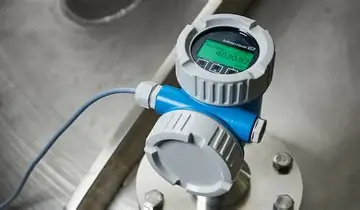 Een digitale industriële manometer met een groen display waarop “400,00” staat. Hij is gemonteerd op metalen apparatuur en aangesloten met een kabel, wat precisie uitstraalt.