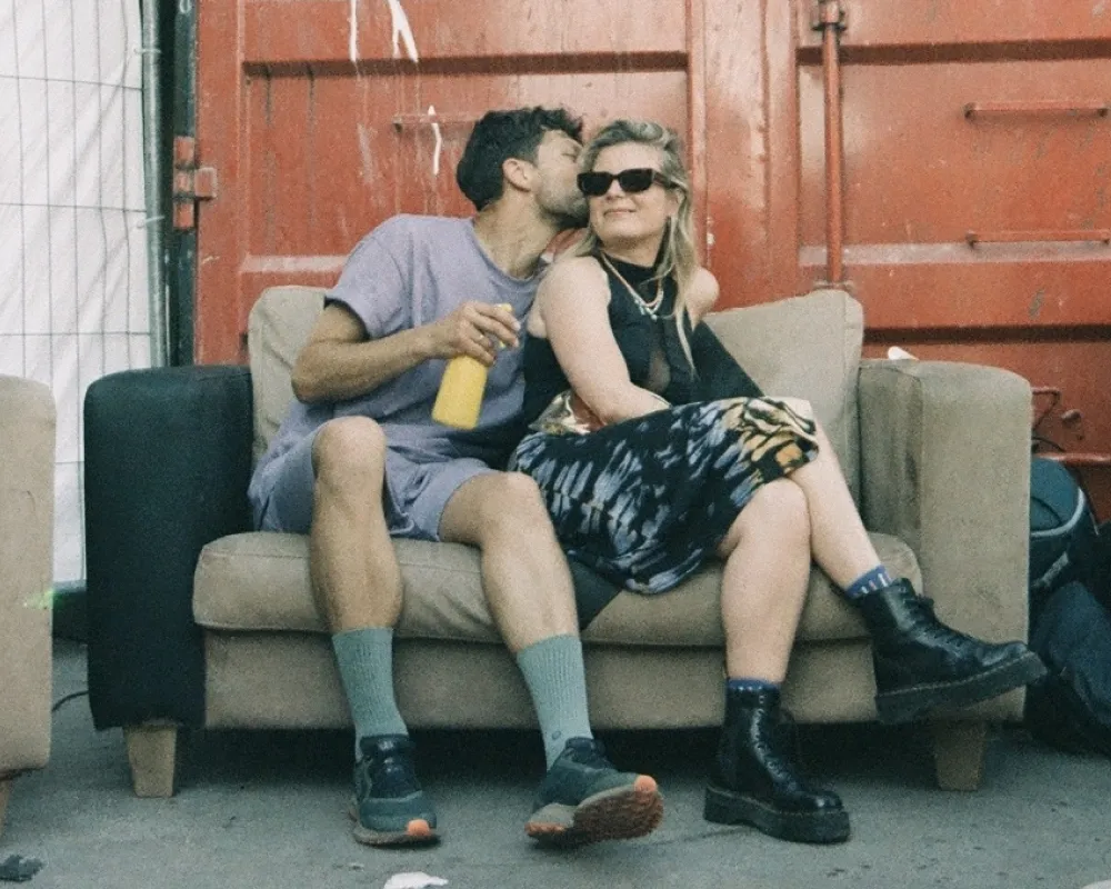 Two people on a couch at DOK53 giving each other a kiss