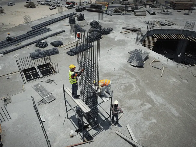 A construction site with a man standing on a scaffold.