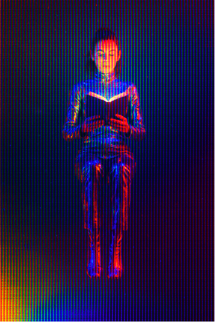 A futuristic woman reading a book.