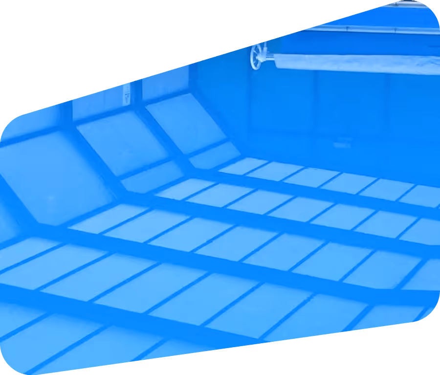 Indoor swimming pool lanes with lane dividers and sunlight reflections on the water.