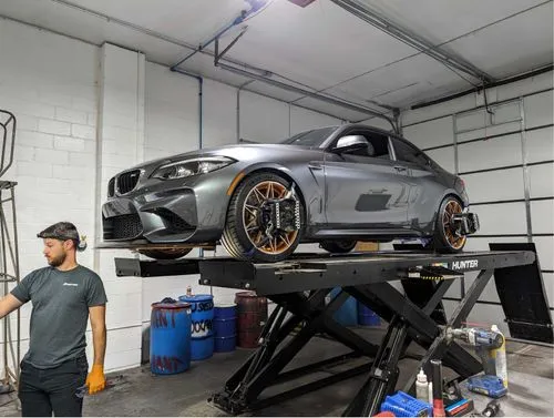 Modern silver BMW on a lift inside the Enthusiast Auto shop