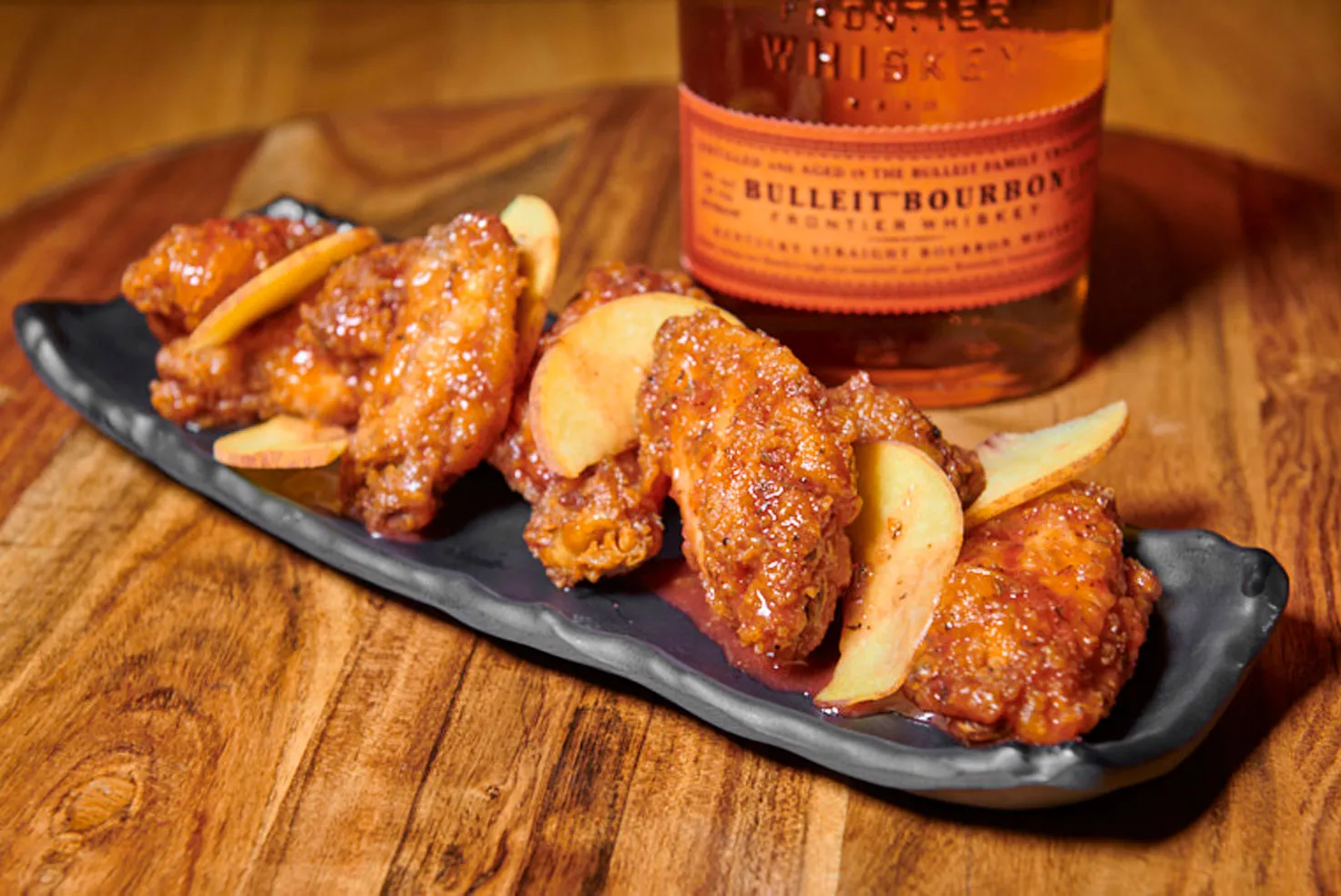 Crispy wings glazed with a sweet peach and smoky bourbon sauce, offering a perfect harmony of sweetness and heat.