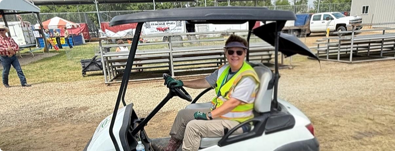 a person sitting in a golf cart giving free rides to the fair