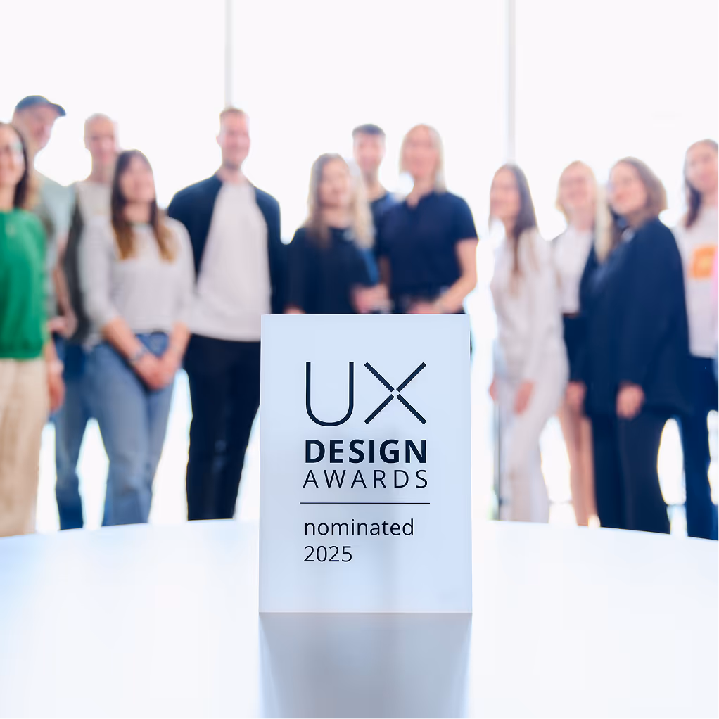A group of people standing behind a prize from UX design awards.