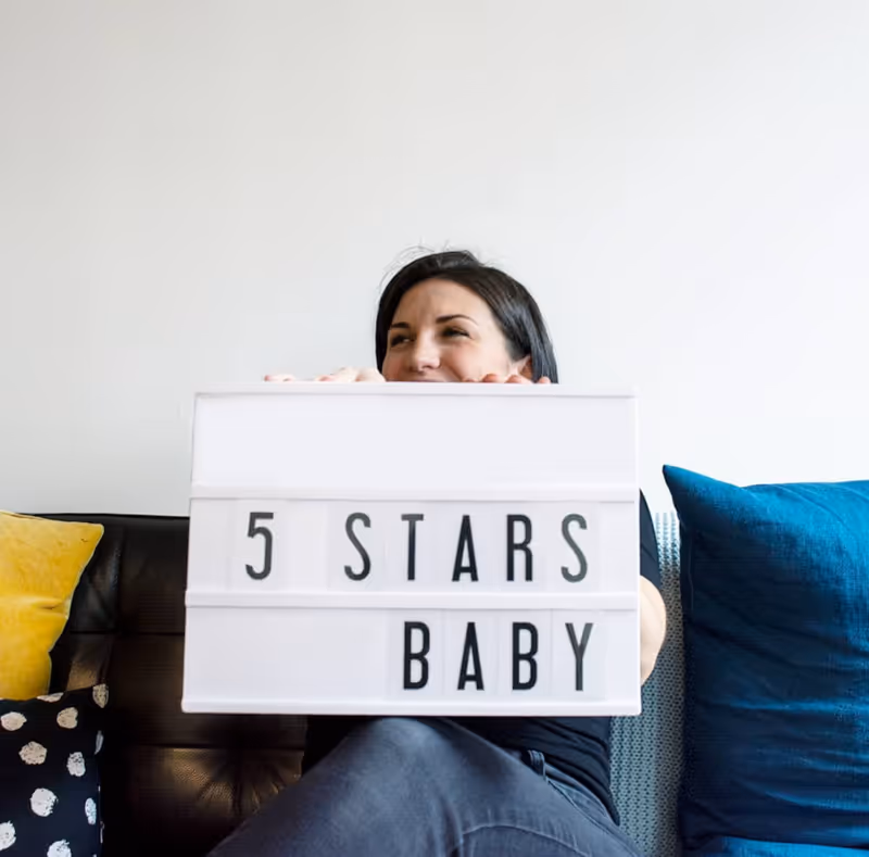 Devyn holding a lightbox that says '5 Stars Baby'.