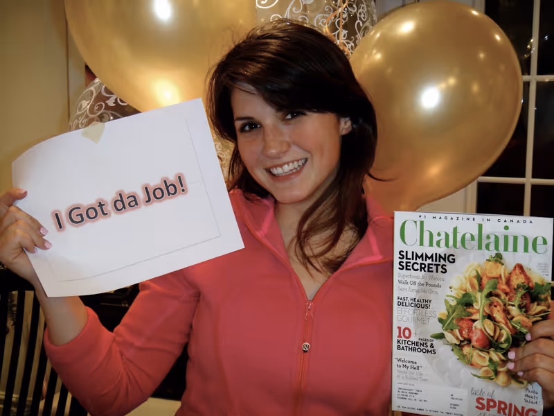 Devyn holding Chatelaine magazine and a sheet of paper that states 'I Got da Job!'.
