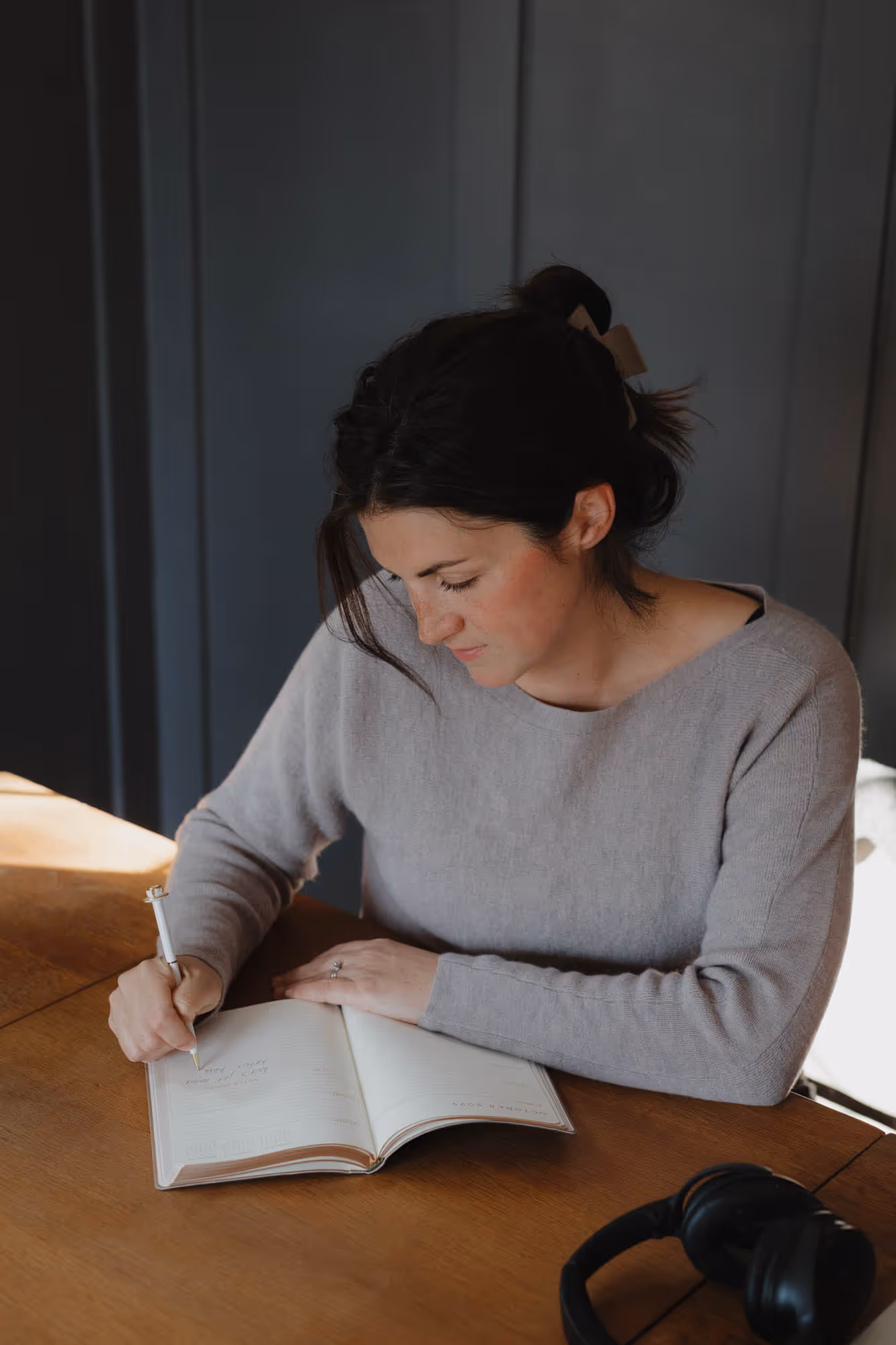 Devyn sitting at her desk, writing in her notebook.
