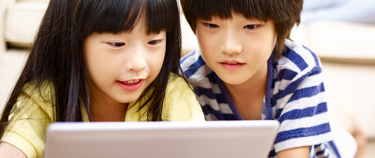 two kids looking at a computer
