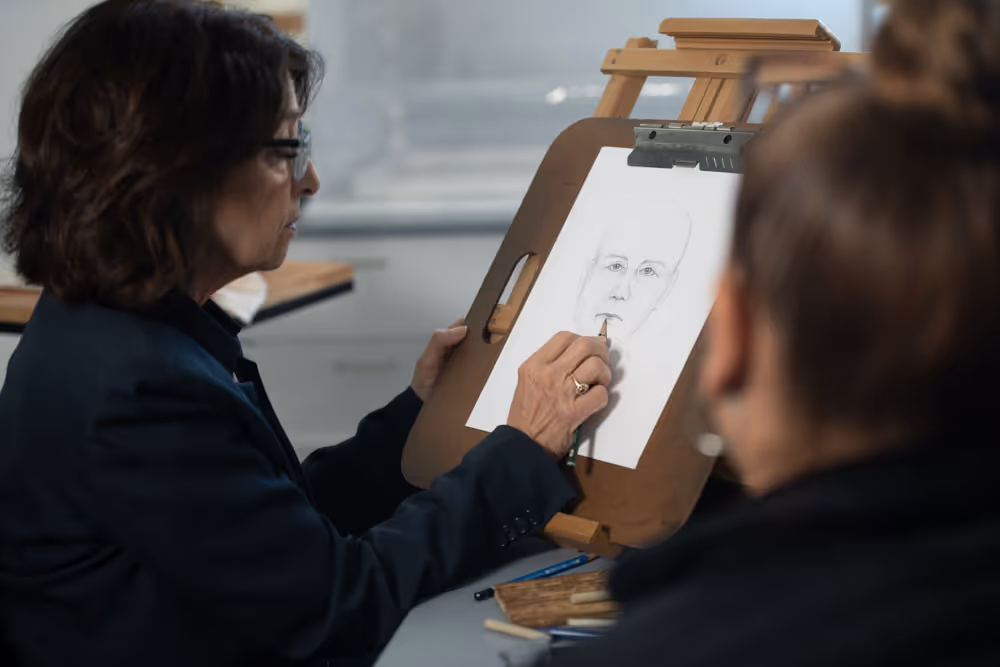 A woman drawing the portrait of a man
