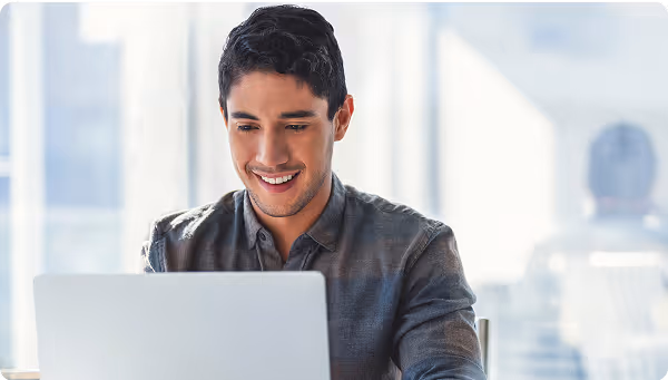 young hispanic man smiling at computer