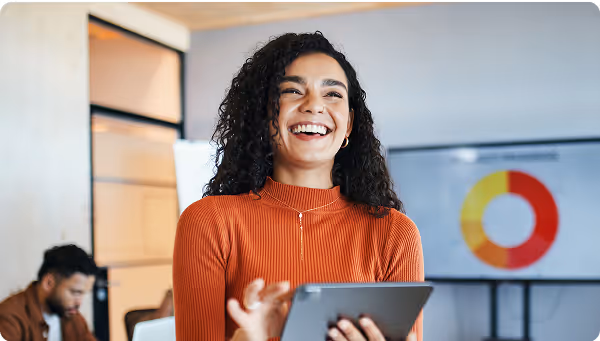 young women smiling while holding tablet