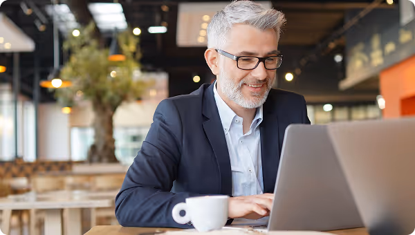 man working and smiling at laptop