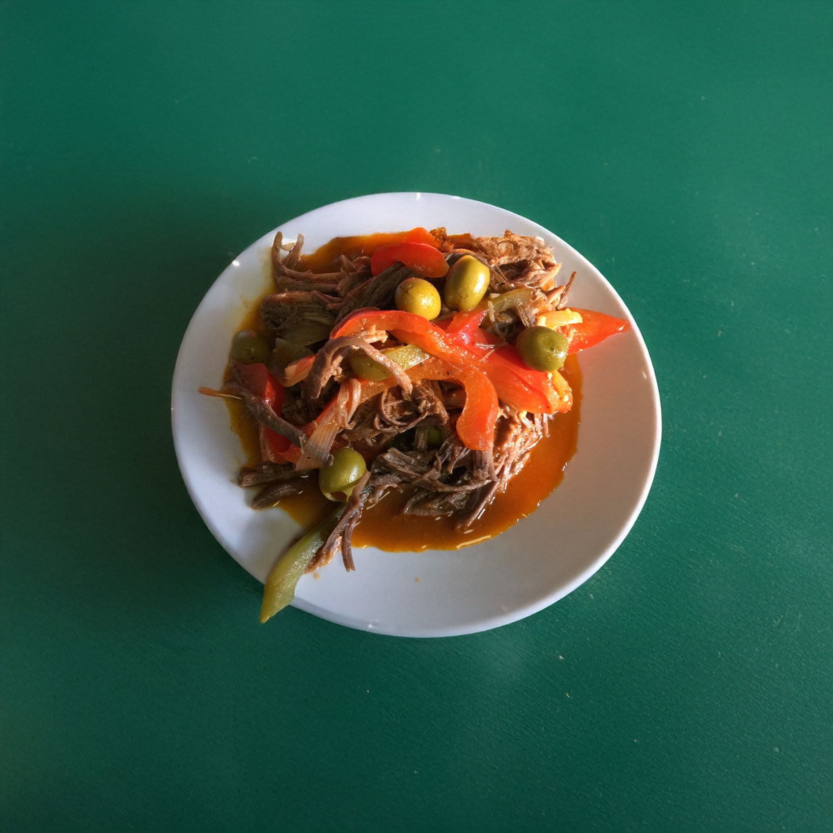 A plate of Ropa Vieja with olives.