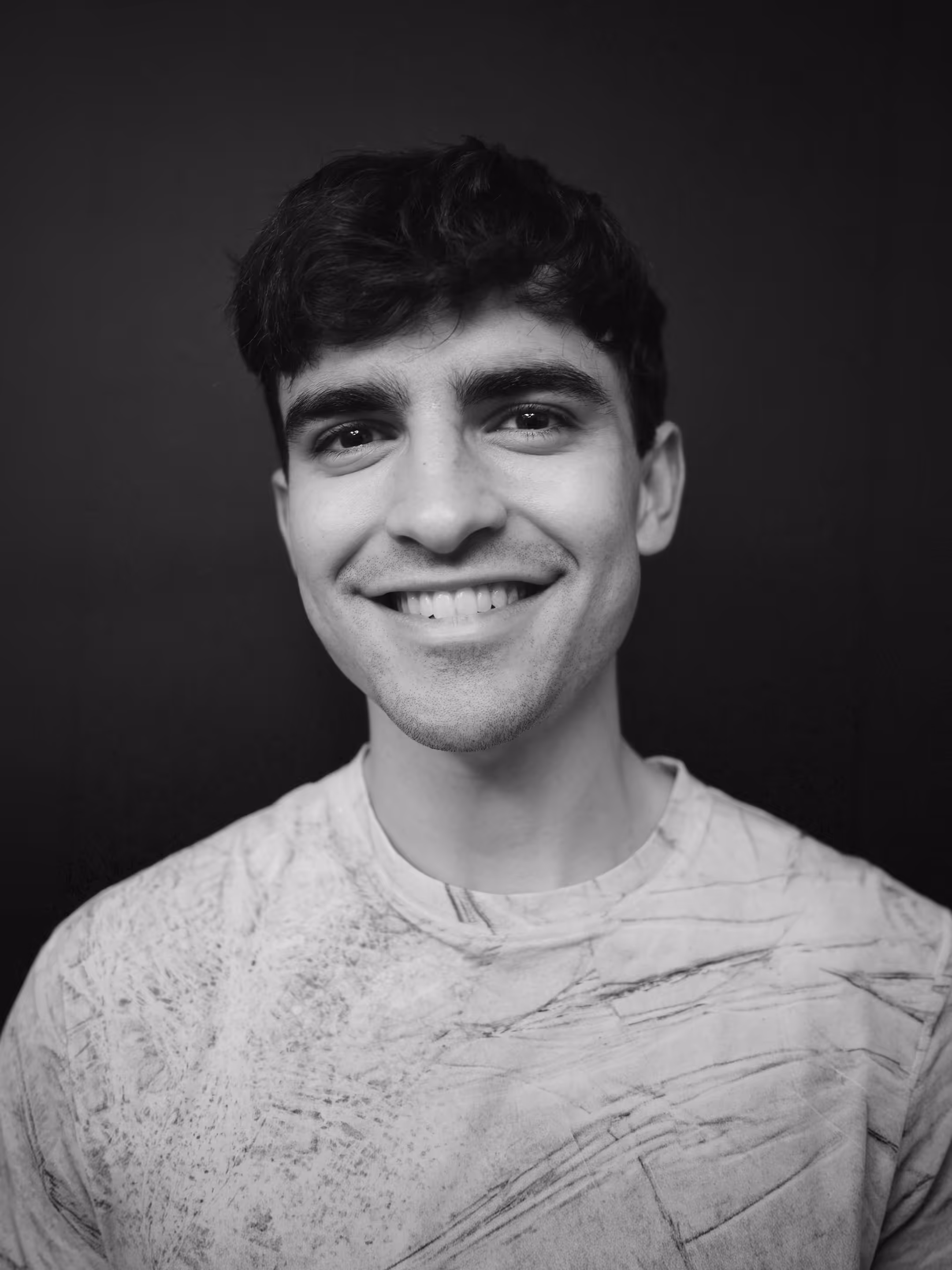 Headshot of Marshall Murphy, a graphic and motion designer, smiling in a minimalist studio setting.