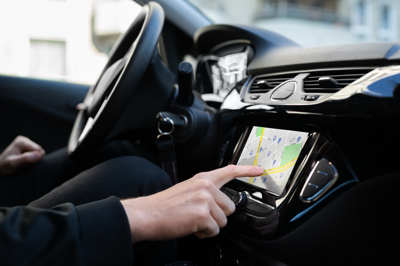 A person in a vehicle operating a touch screen head unit
