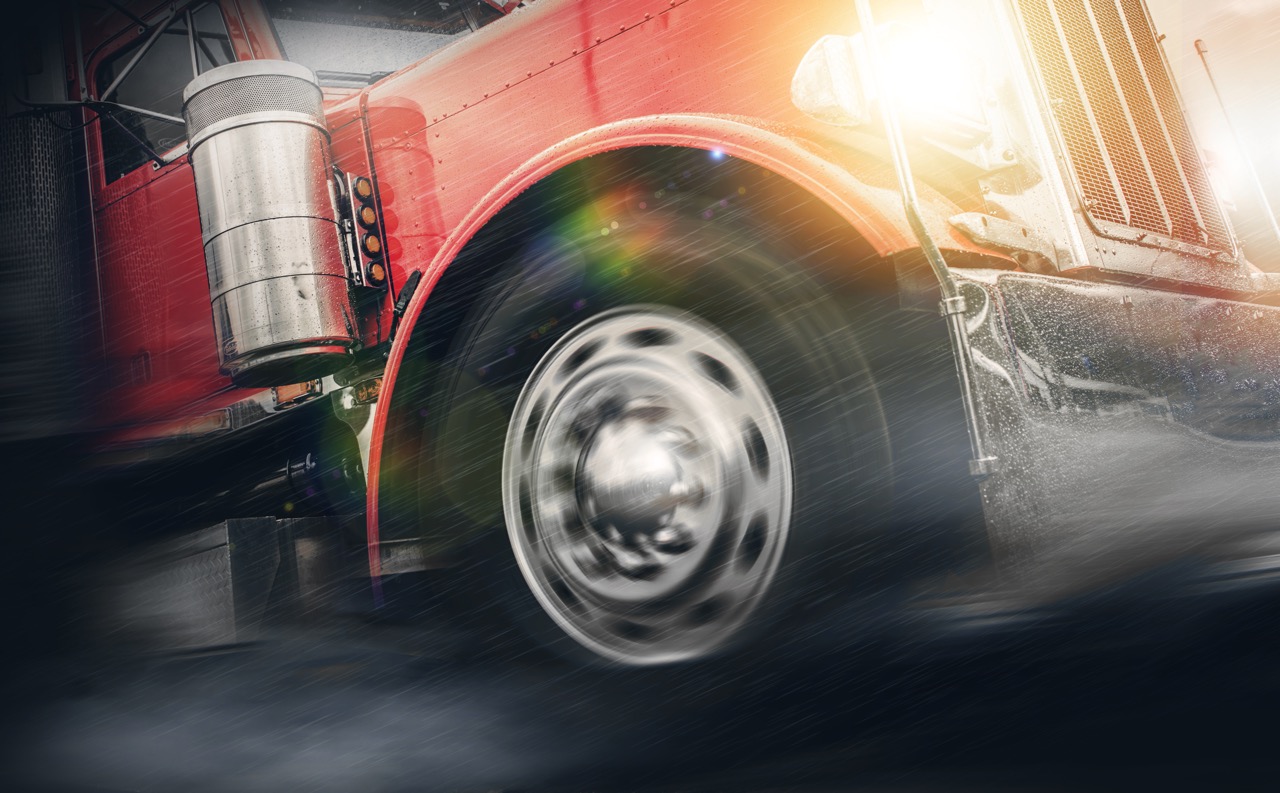 A semi-truck driving in the rain