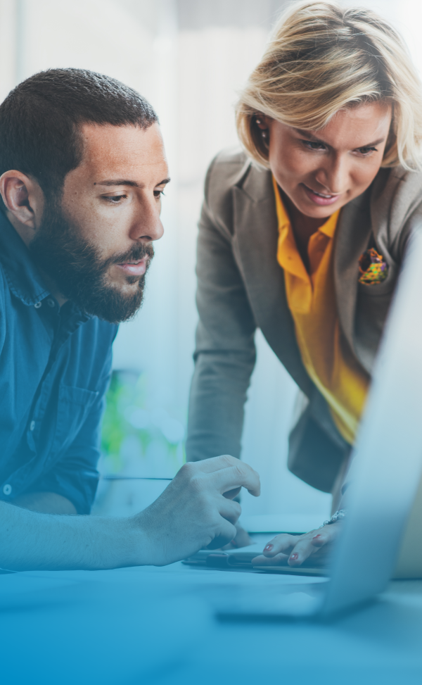 A man and a woman looking over a computer