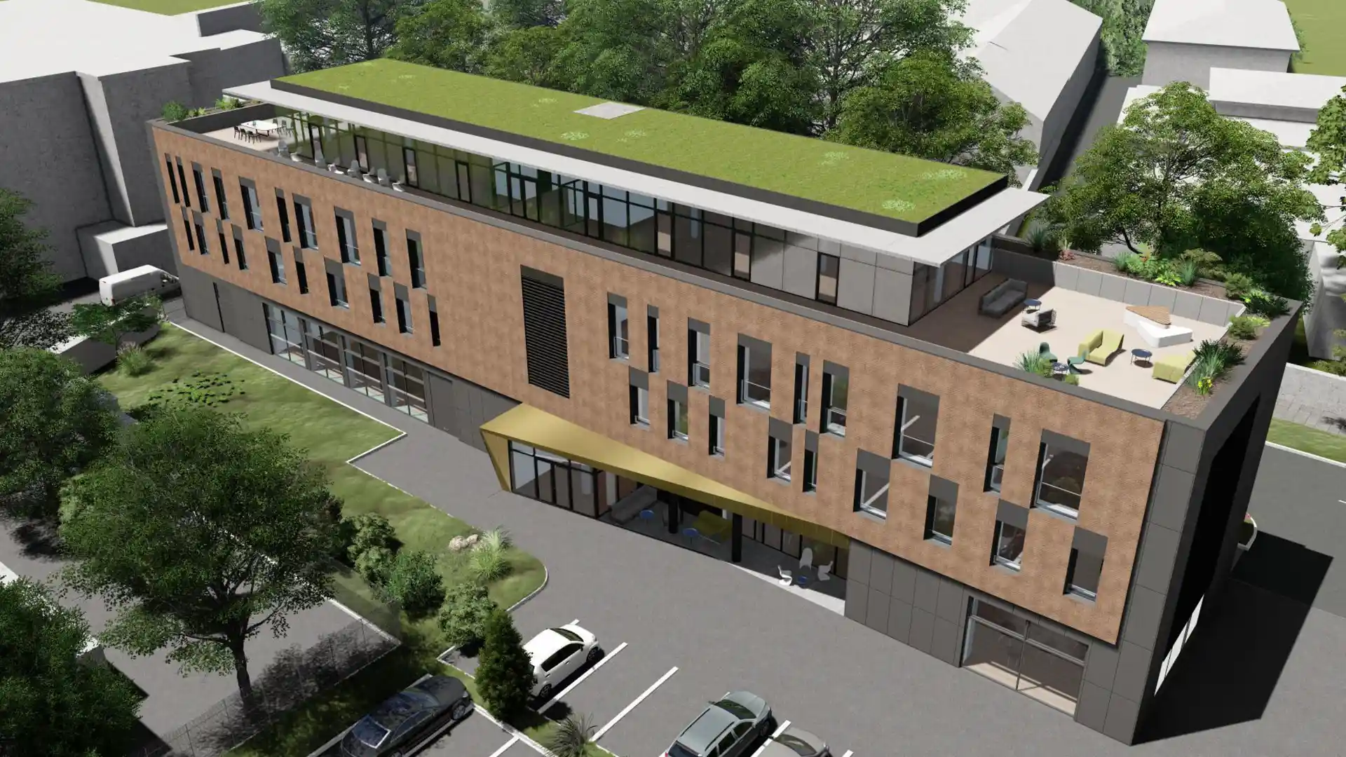 Modern irodaépület madártávlati nézetből, zöldtetővel és tetőterasszal, körülötte parkoló és gondozott zöldfelület.