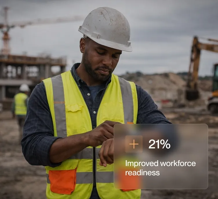 Construction worker in a white hard hat and yellow vest checking his watch at a construction site.