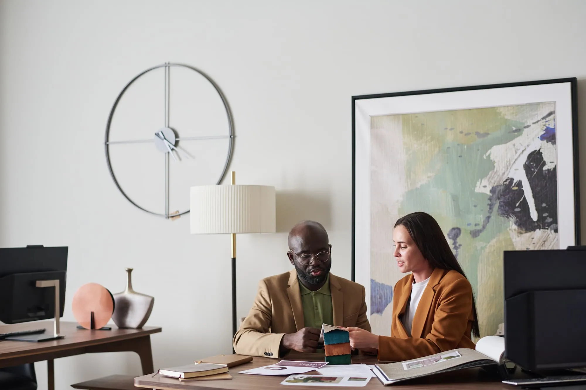 intercultural interior designers looking through catalogue together 