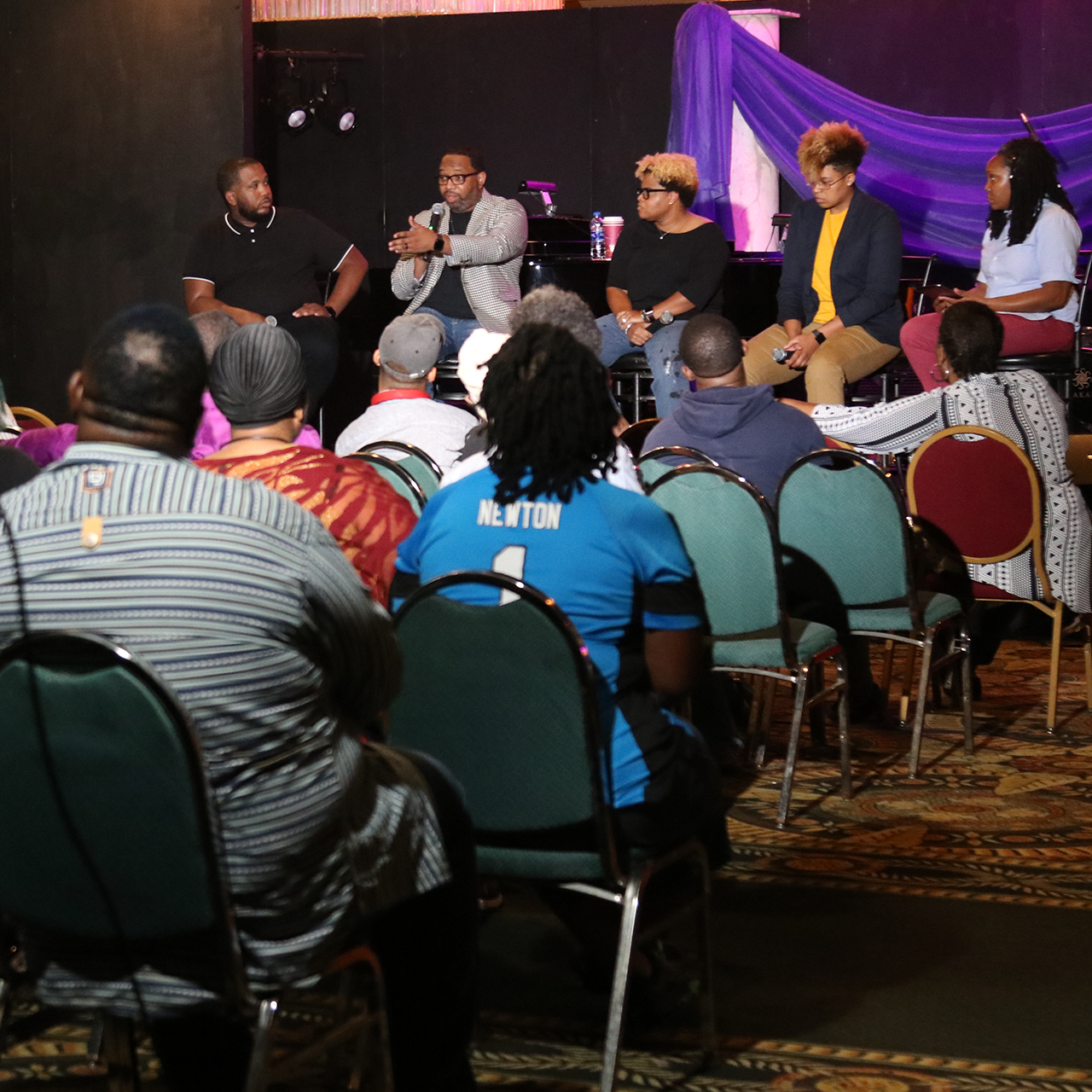 Event shot of panel and audience looking on