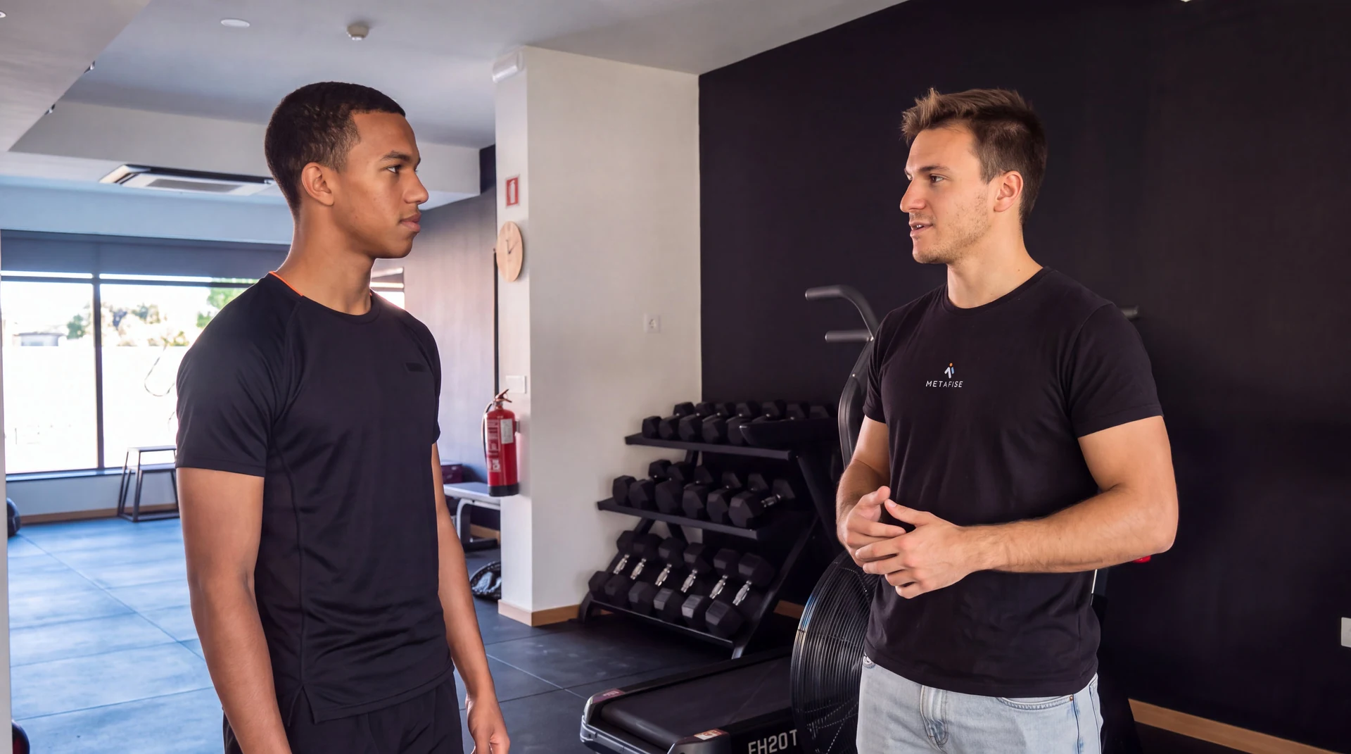 Fisioterapeuta conversa com um atleta no ginásio da Metafise.
