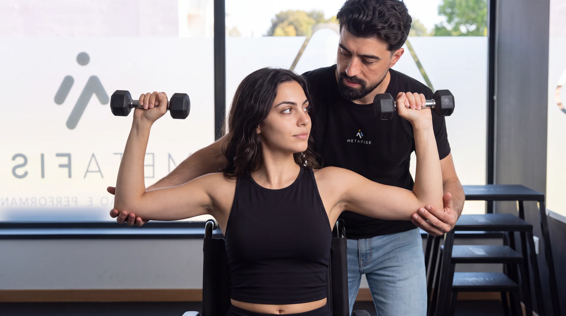 Fisioterapeuta acompanha um exercício de braços com halteres.