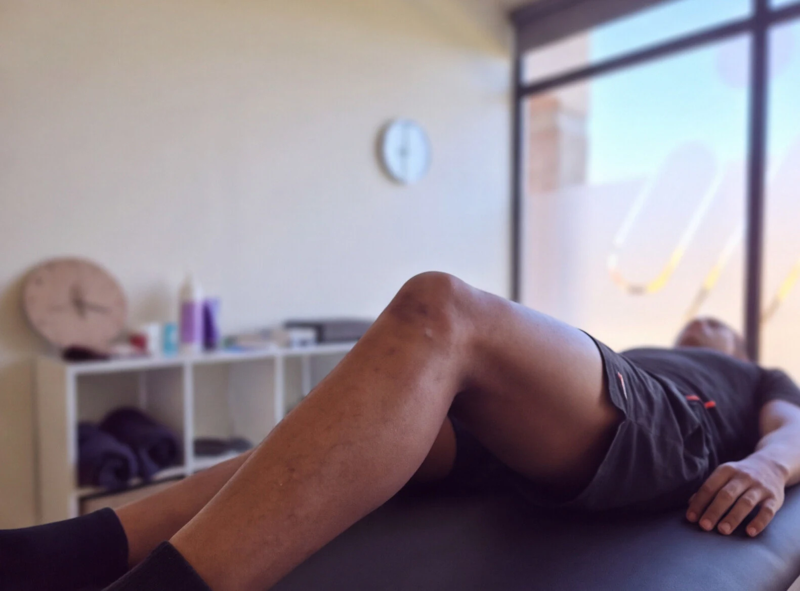 Utente com o joelho fletido durante um exercício na marquesa.