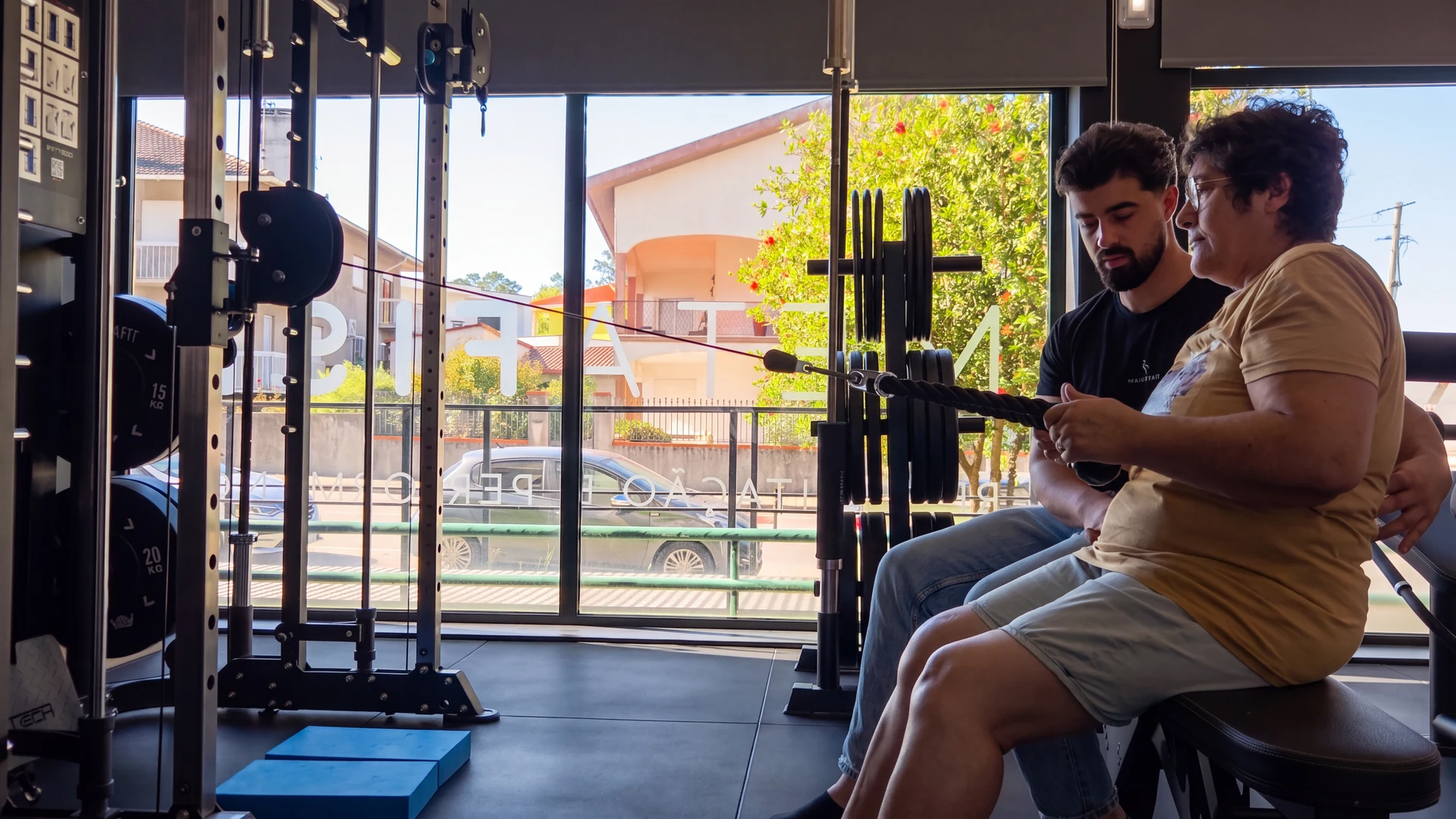 Fisioterapeuta orienta uma utente durante um exercício no ginásio.