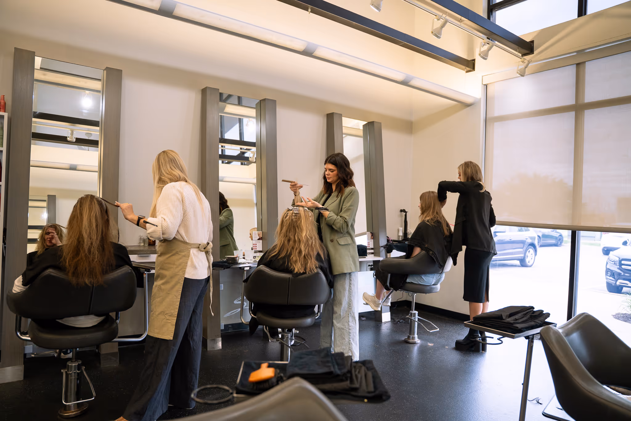 Stylists working on clients hair in trendy salon