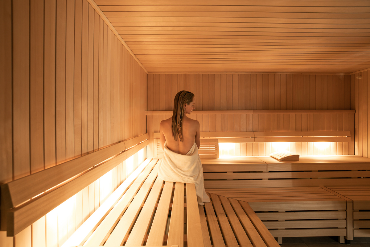 commercial photo of a woman in a sauna at a luxury spa