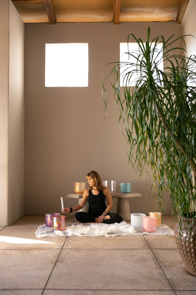 commercial photography of a woman practicing sound bowls