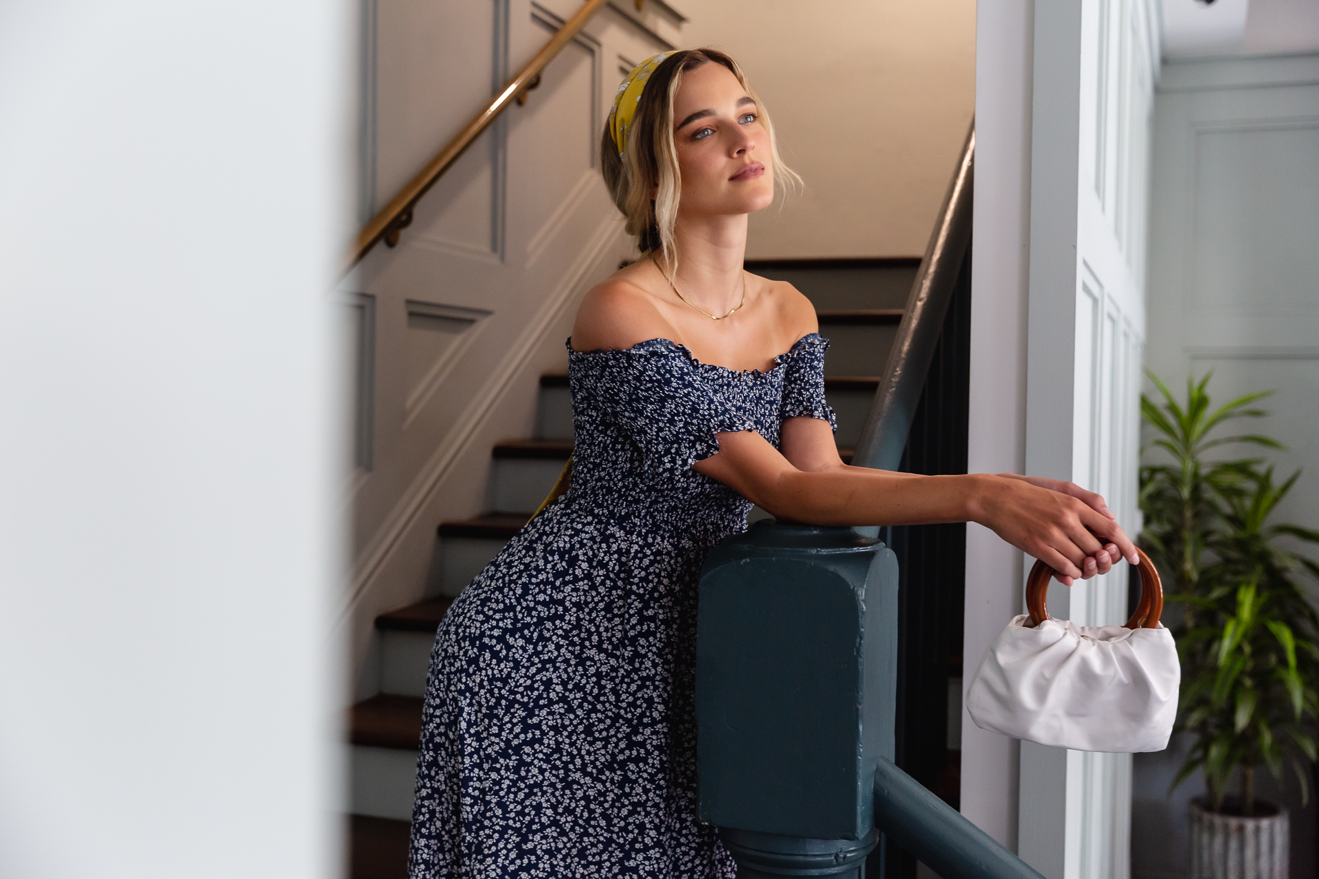 commercial photo of a woman standing on the stairs in a hotel lobby 