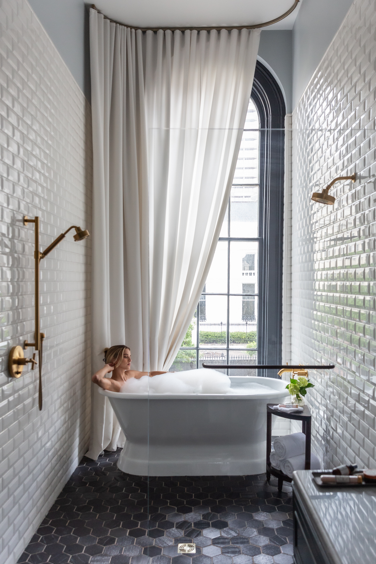 commercial photography of a woman in a luxurious bathtub in a hotel