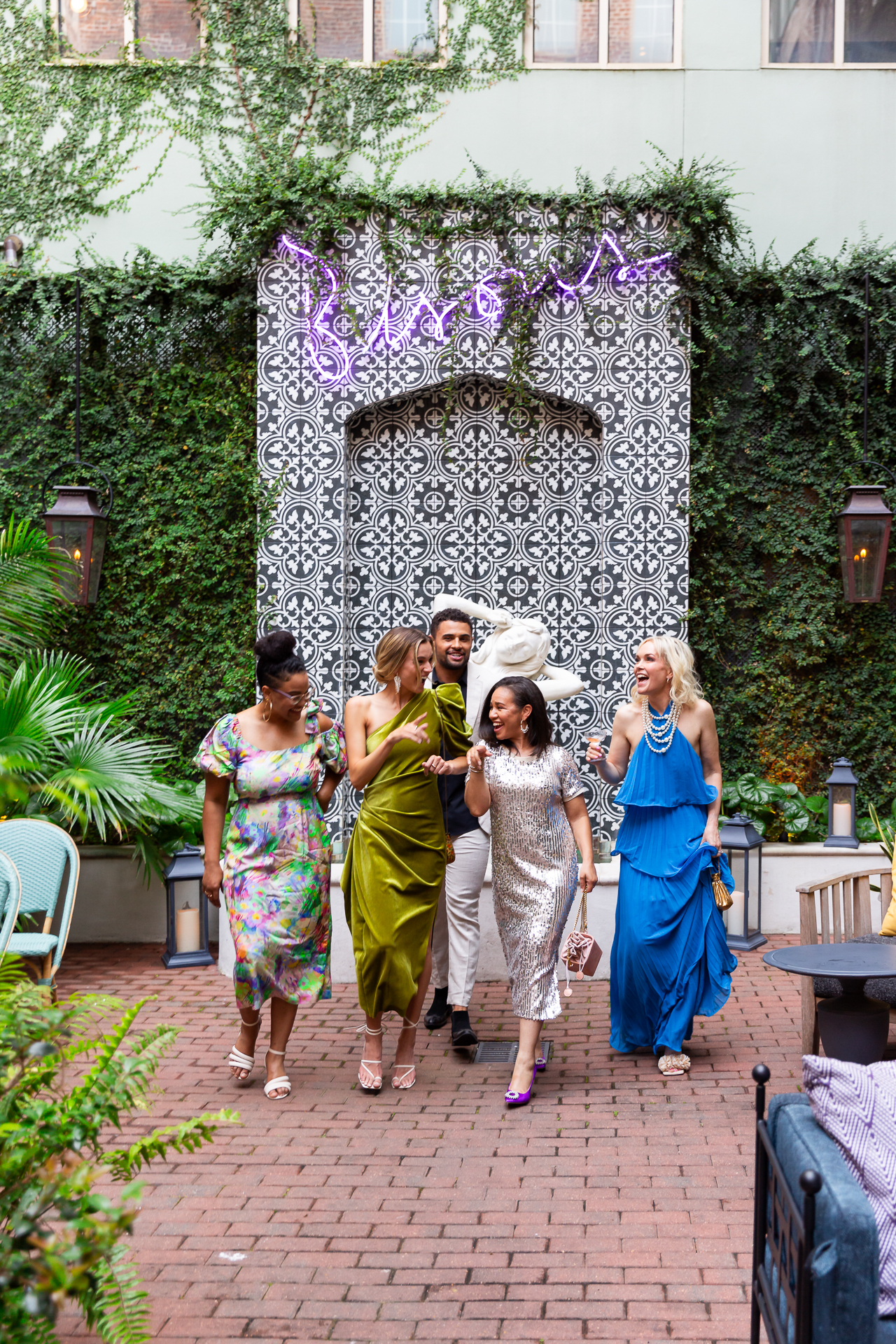 commercial photo of a group of friends walking in a hotel courtyard