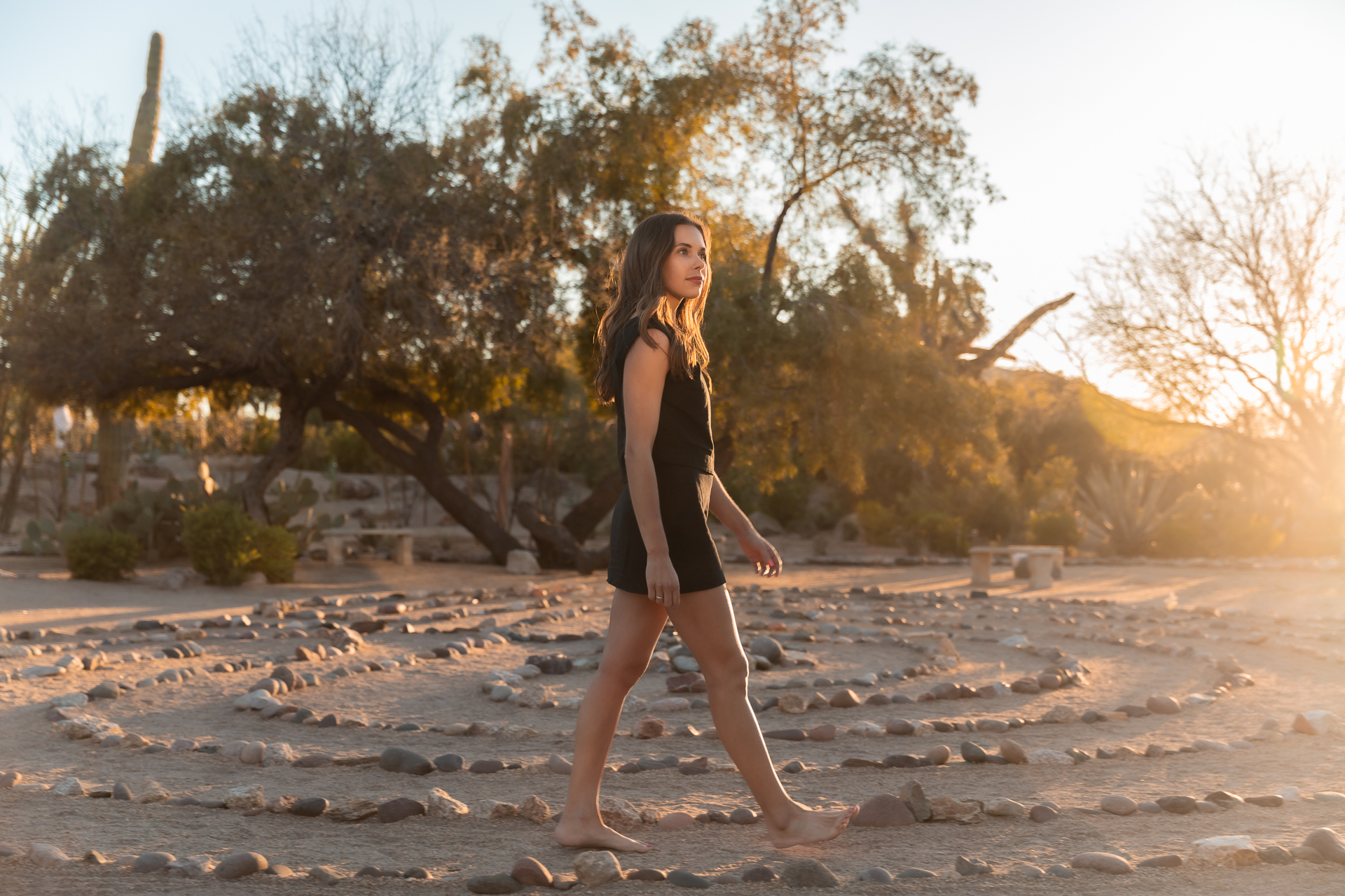 commercial photography of a woman walking through a labyrinth at a luxury resort in the desert