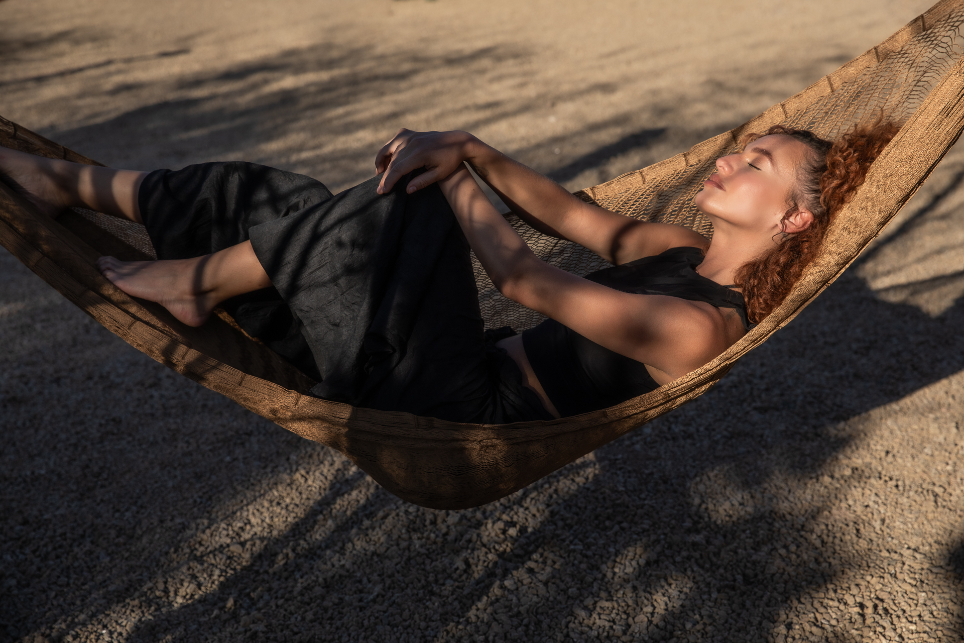 commercial photography of a woman relaxing in a hammock in the desert