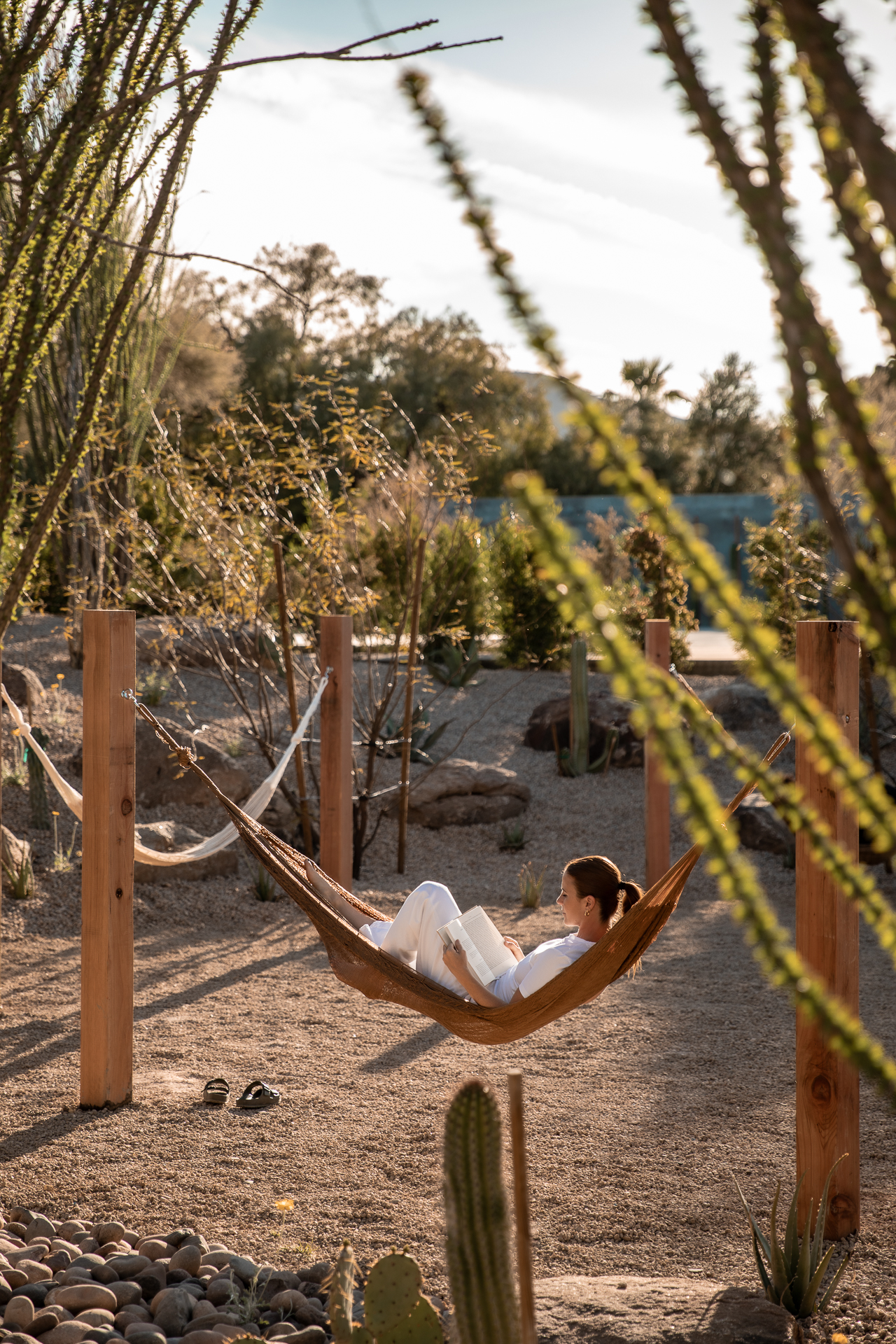 commercial photography of a woman relaxing in a hammock in the desert