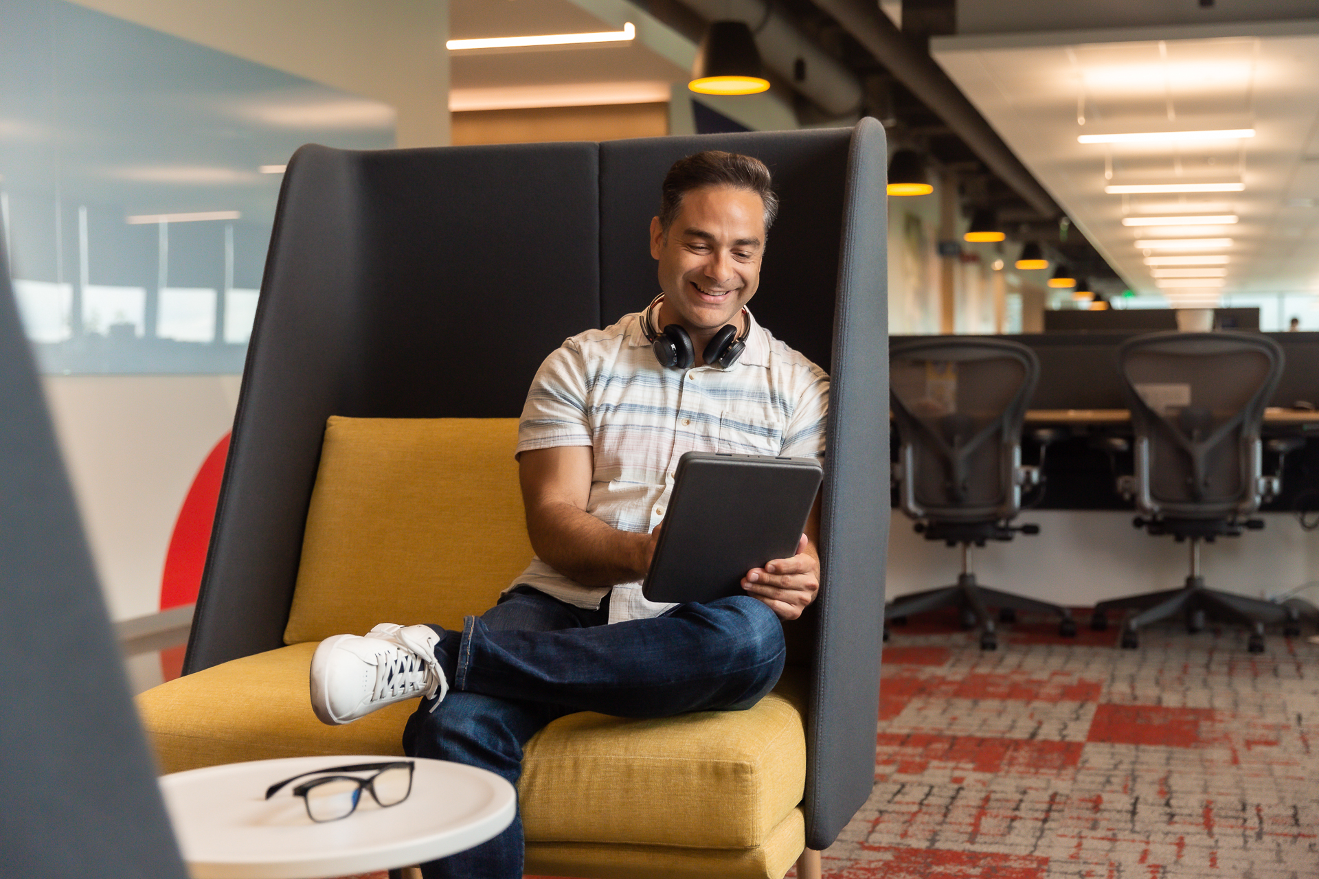 commercial photography of a man working on his laptop in a modern office space