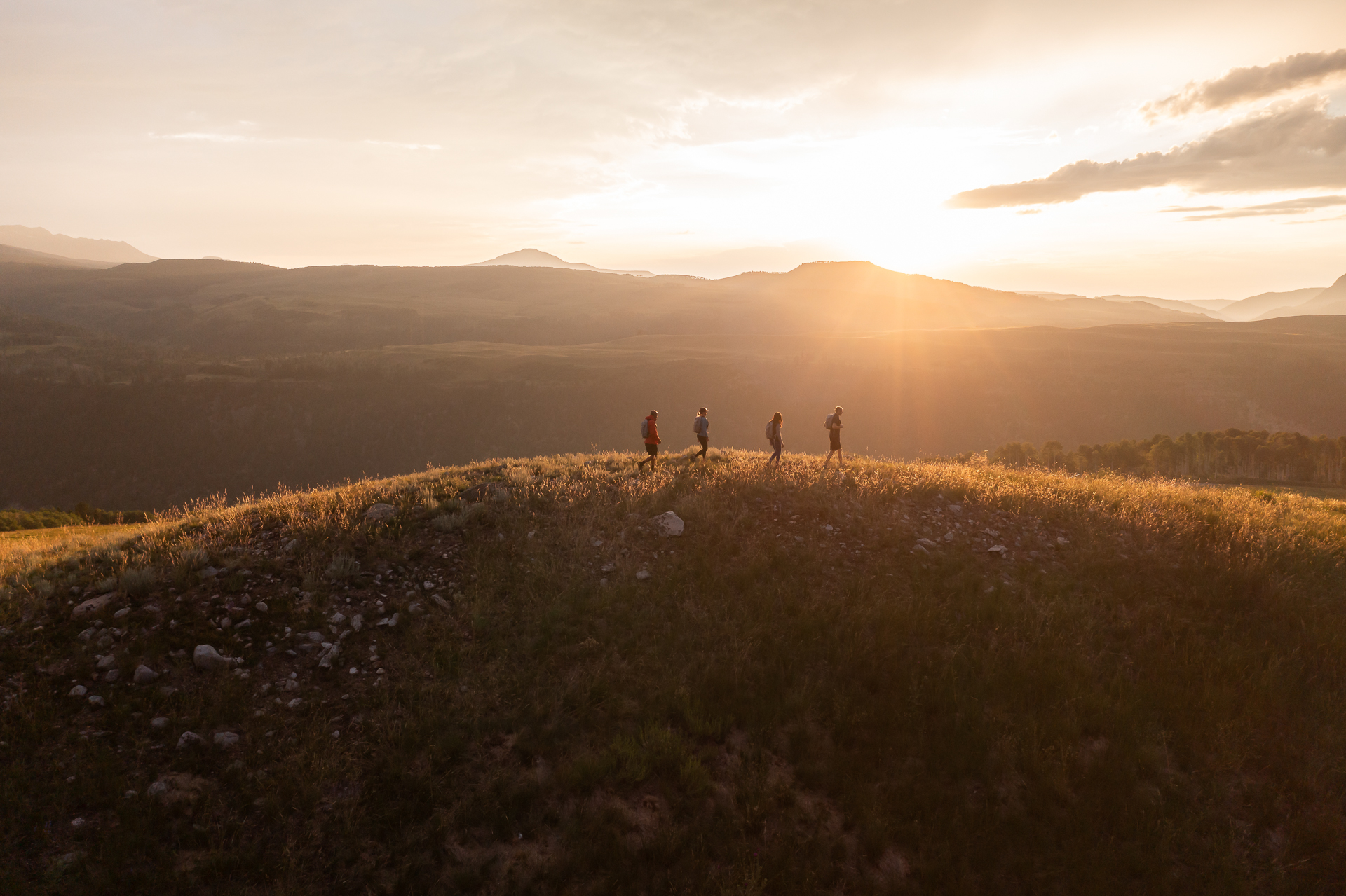commercial photography of a group of hikers on a mountaintop at sunset in Telluride, Colorado
