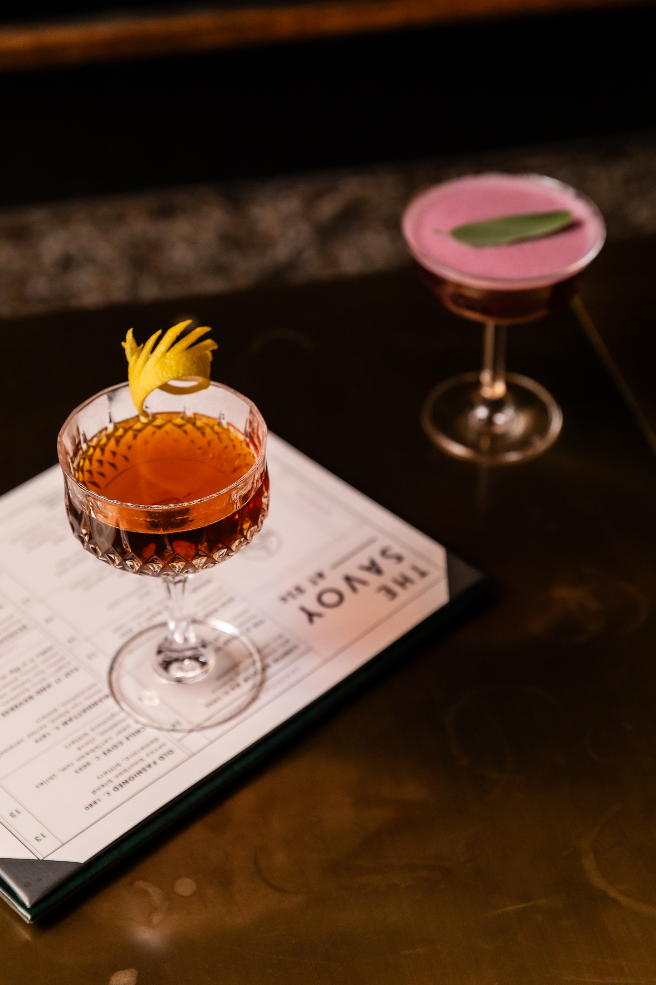 commercial photography of two cocktails and a bar menu
