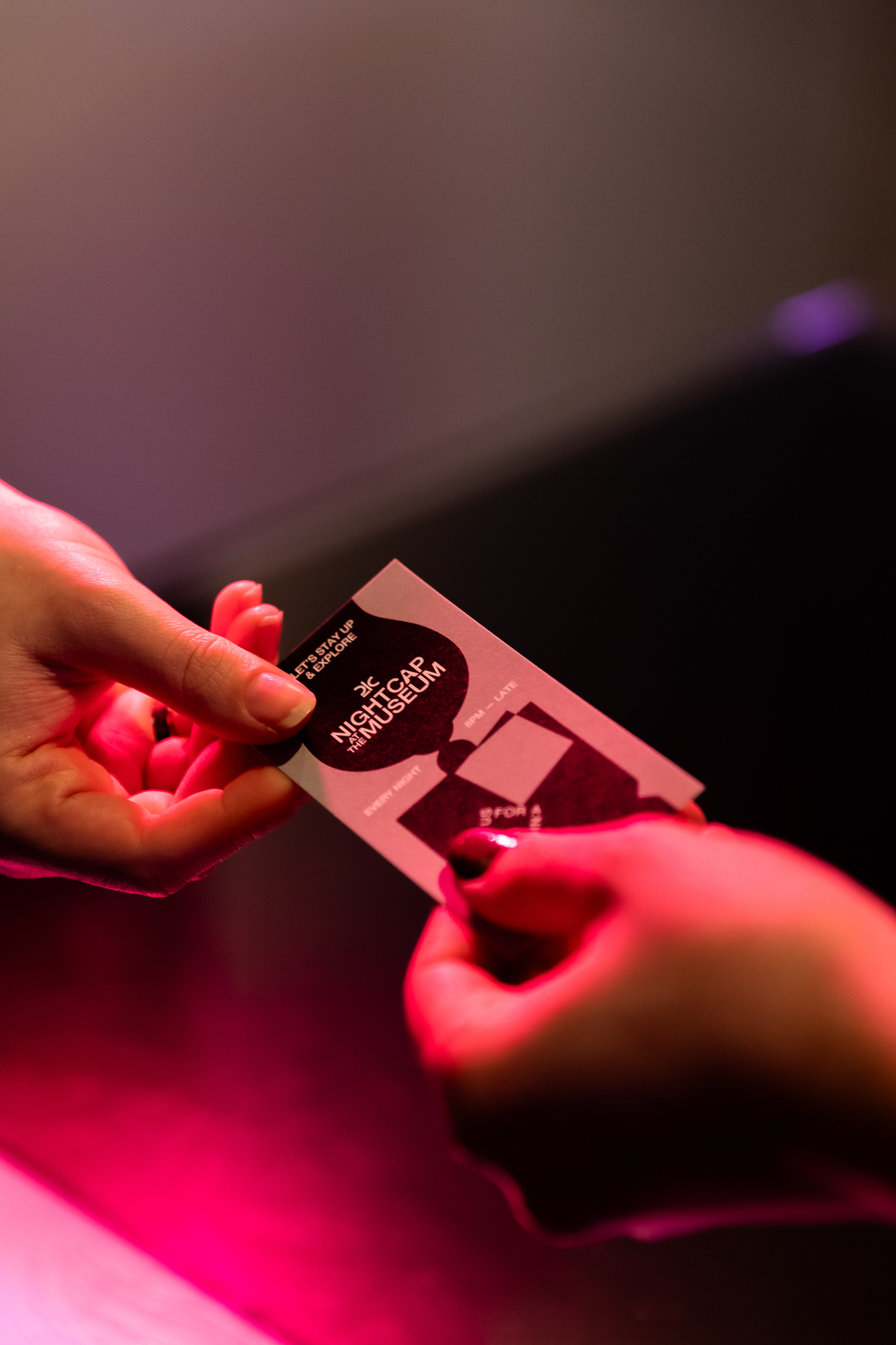 commercial photography of a drink ticket being handed across a hotel desk