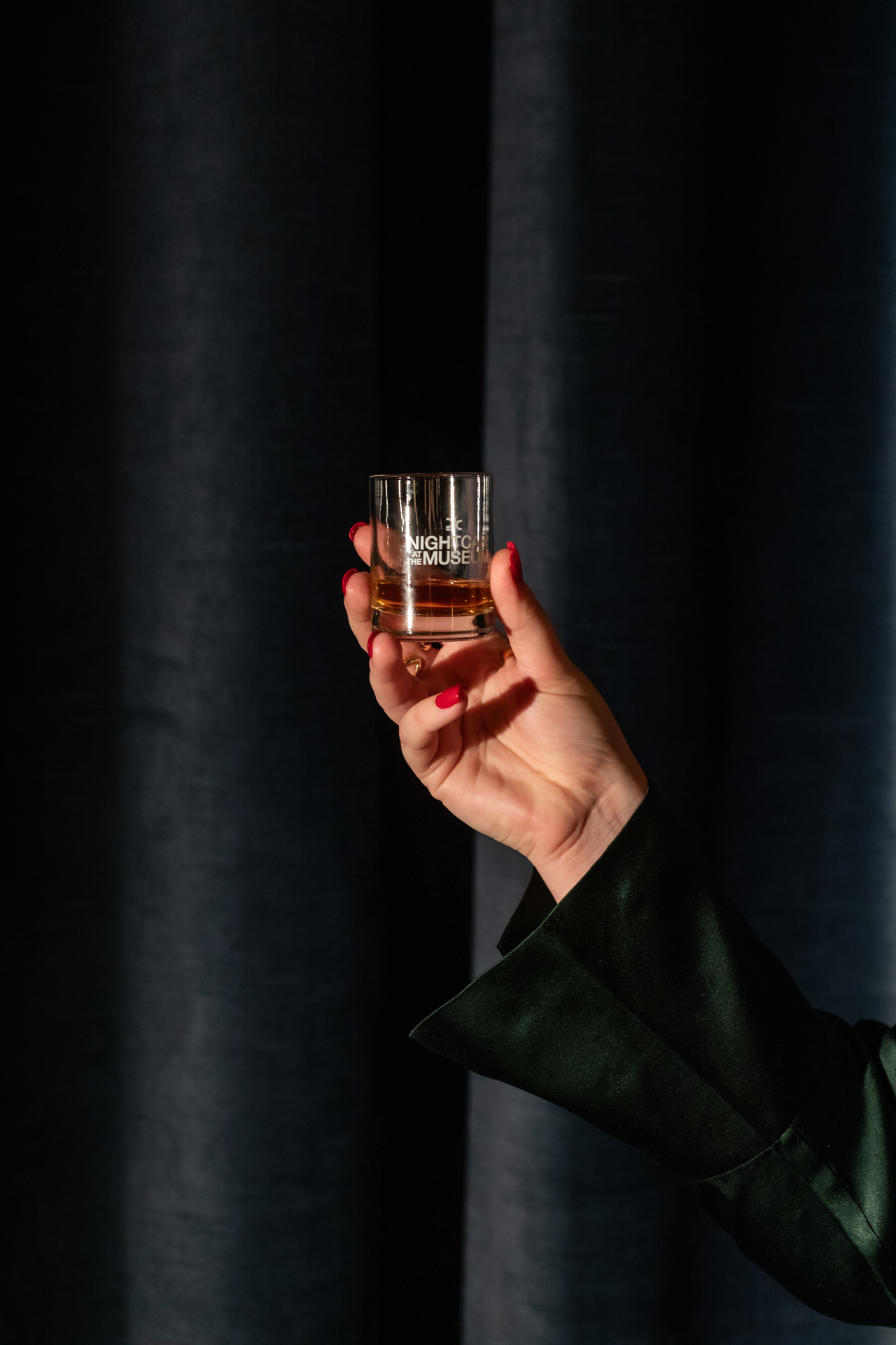 commercial photography at 21C museum hotel of a small whiskey glass being held by a woman's hand