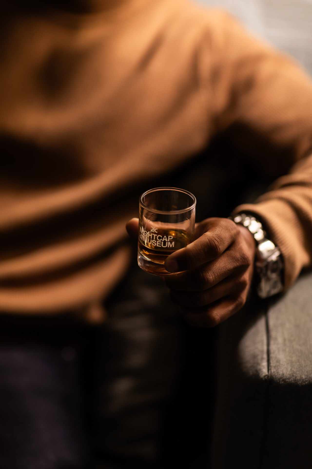 commercial photography at 21C museum hotel of a man holding a small nightcap of whiskey