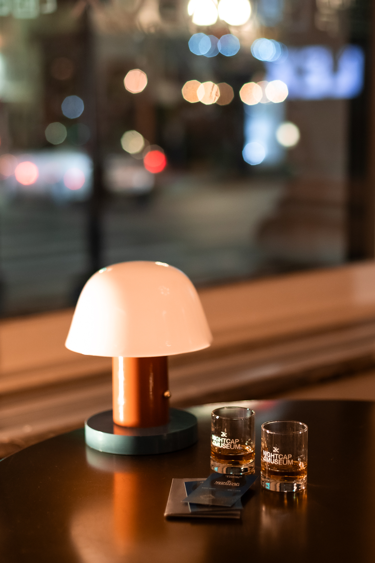 commercial photography at 21C museum hotel of a lamp and two small glasses of whiskey in front of a window