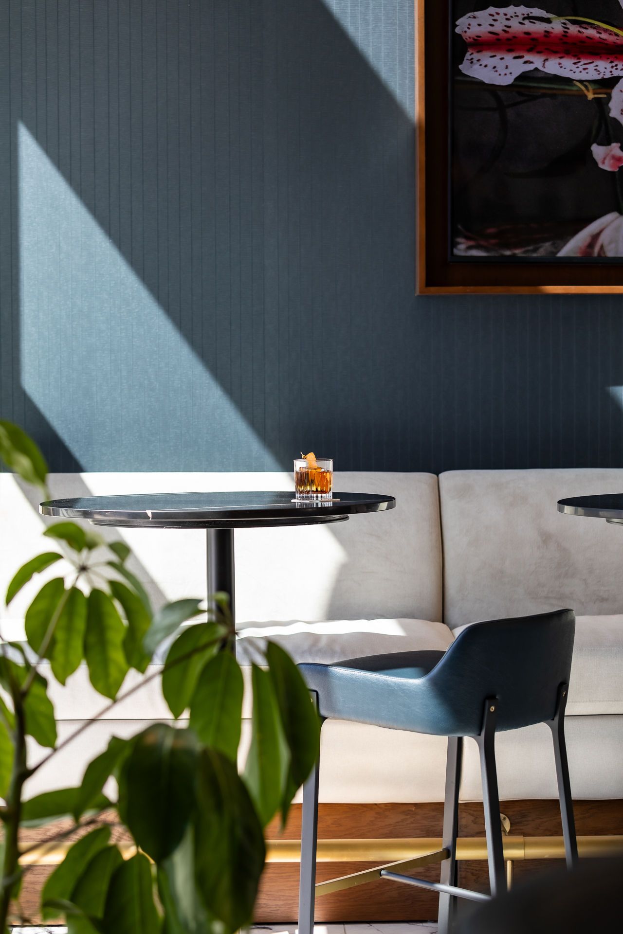 commercial photography of a table in the sunlight with a plant and cocktail at Tempo Nashville
