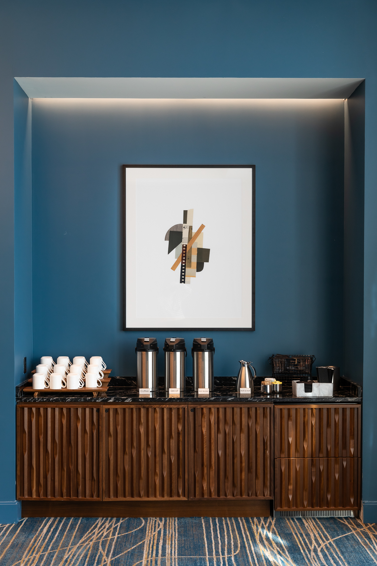commercial photography of artwork on a blue wall with coffee set up