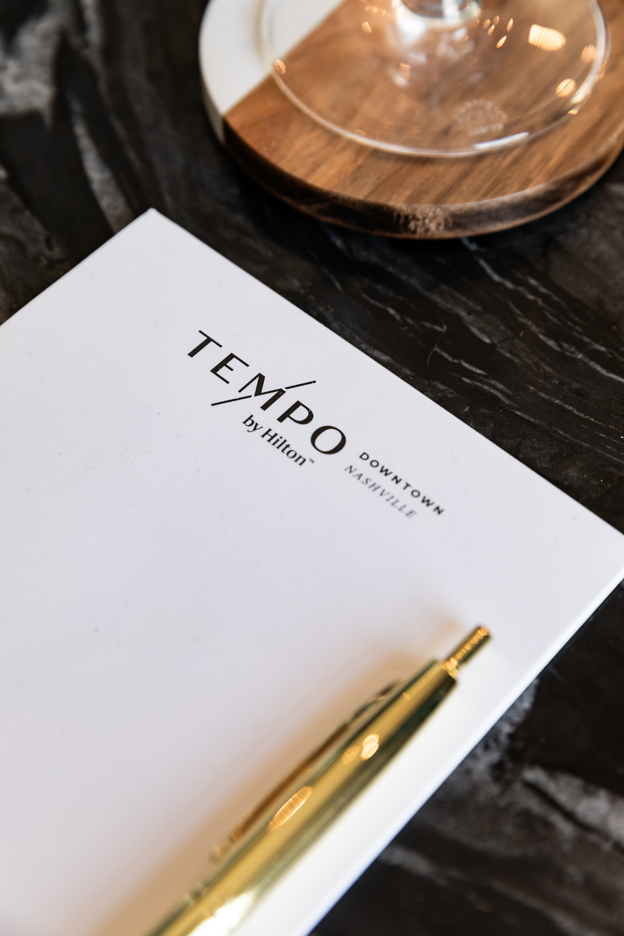 commercial photography of a small note pad and gold pen at tempo nashville