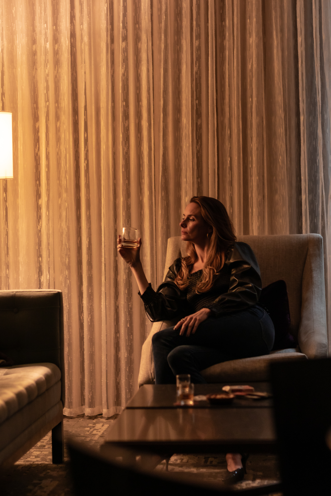 commercial photography at 21C museum hotel of a woman holding a drink in her hotel room at night
